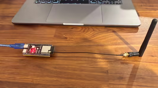 ESP32-S3 with an external antenna beside a laptop